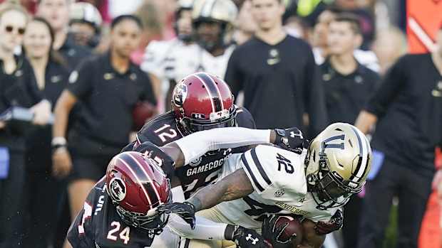 Oct 16, 2021; Columbia, South Carolina, USA; Vanderbilt Commodores running back Patrick Smith (42) is tackled by South Carolina Gamecocks defensive back Marcellas Dial (24) and South Carolina Gamecocks defensive back Jaylan Foster (12) at Williams-Brice Stadium. Mandatory Credit: David Yeazell-USA TODAY Sports